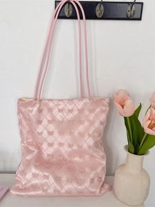 Pink ribbon quilted tote bag for women with long handles hanging on a wall hook
