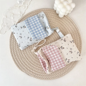 Detail of floral and plaid fabric nurse pouch organizer with hanging strap and button