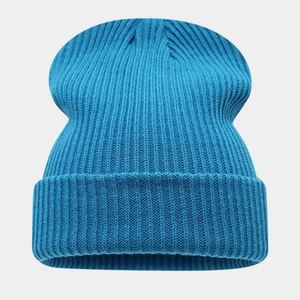 Détail du bonnet en maille bleue avec une texture côtelée épaisse et un bord replié