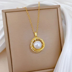 Detail of gold titanium bird nest necklace with white pearl and sparkling crystals