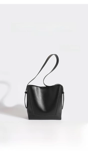 Detail view of a minimalist black matte leather bucket bag with premium finish