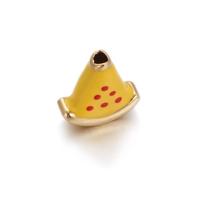 Macro detail of yellow enamel spacer bead with red dots and gold plated edges for DIY jewelry