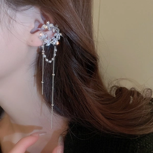 Detail of silver C-shaped ear cuff with sparkling zircon floral patterns and long tassels