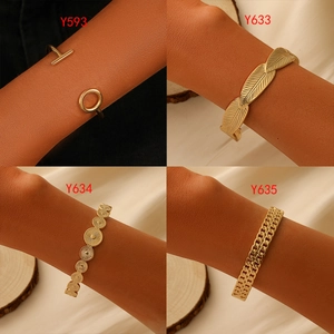 Detailed views of four gold-plated hollow chain and geometric open bangles on a model
