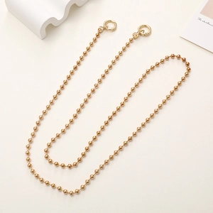 Detail of golden metal ball chain with dual spring clasps for bags and phone cases