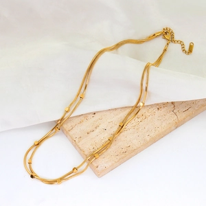 Detail of 18K gold double layer snake chain necklace with square bead charms and lobster clasp