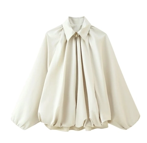 Detail of beige wrinkled long sleeve shirt with a sleek zipper neckline and smooth texture
