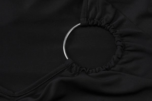 Détail du tissu plissé noir avec un anneau métallique argenté poli et texture raffinée