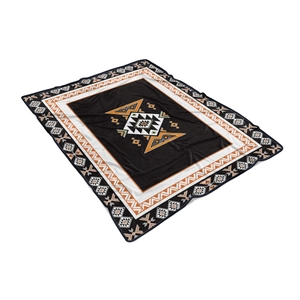 Detail of tribal geometric pattern on soft black flannel throw blanket with orange accents