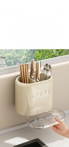 Detail of wall-mounted kitchen organizer with cutlery slots and removable drip tray