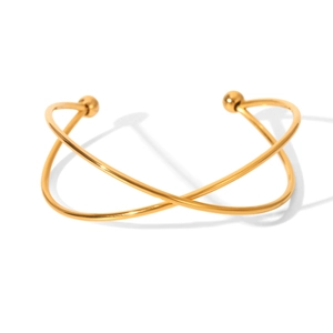 Gold stainless steel cross-over open bangle with spherical ends on white background