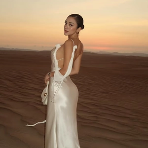 Elegant white backless satin maxi dress with cowl neck shown on model in desert sunset