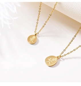Macro detail of gold rose engraved pendant necklaces on a clean minimalist white background