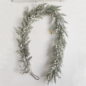 Detail of Norfolk pine garland with white berries and realistic snowy flocked needles