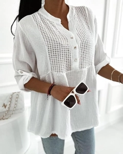Detail of white button-up blouse featuring delicate lace stitching and a stand collar