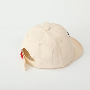 Rear view of beige baby baseball cap showing the adjustable tie and red smiley face label