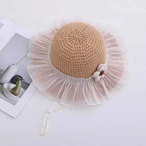 Close-up of kids straw sun hat with white organza ruffle brim and flower detail