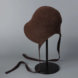 Close-up of deep brown crochet knit bucket hat with tie straps and wavy brim design