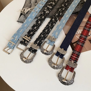Detail of vintage bohemian waist belts featuring star cutouts and floral engraved buckles