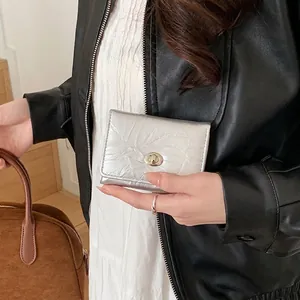 Portefeuille argenté en cuir plissé pour femme avec fermoir tournant en métal élégant