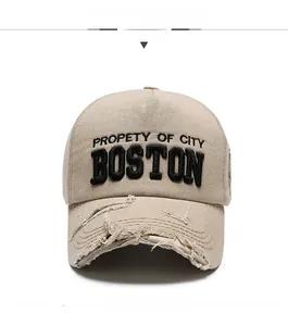 Close-up of beige denim cap featuring black 3D Boston embroidery and distressed brim details