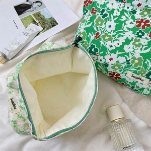 Detail of green floral canvas makeup bag with zipper closure and durable inner lining