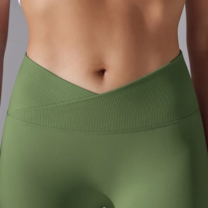 Close-up of V-shaped cross waistband and ribbed texture on green yoga leggings