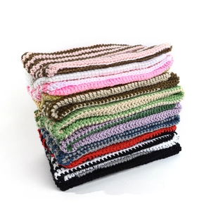 Detail of stacked handmade crochet knit devil ear hats in multiple vibrant colors