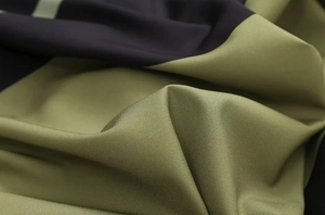 Close-up of olive green and navy blue stitching fabric with fine diagonal weave texture