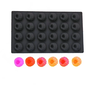 Close-up of a 24-cavity black silicone berry mold with colorful finished mousse cakes