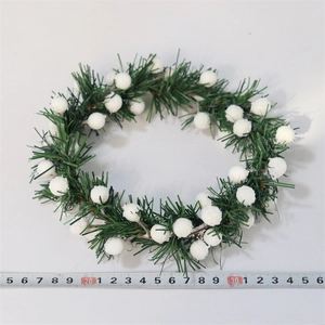 Detailed view of artificial Christmas pine wreath with white berries and size measuring tape