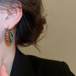Detailaufnahme der Vintage-Ohrringe mit orangefarbenen und grünen Zirkonia-Steinen