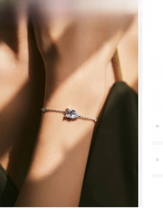 Detailed close-up of S925 silver gold bracelet with emerald-cut and heart-shaped stones