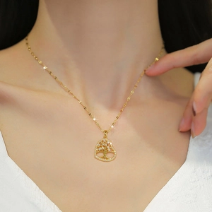 Golden heart necklace with tree of life pendant and small crystals on a fine chain