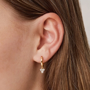 Close-up of gold hoop earrings featuring three sparkling zircon stone pendant charms