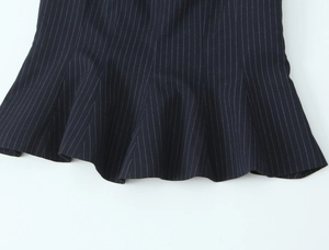 Detailed close-up of dark striped slim fit top showing pleated ruffle hem and fabric texture