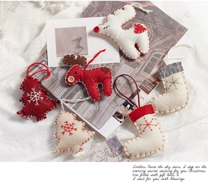 Close-up of handmade Christmas wool felt ornaments including elk and tree designs