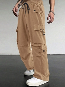 Detailed view of khaki tactical cargo pants with drawstring waist and large flap pockets