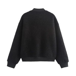 Detailed macro shot of the black sherpa fleece texture on this women's fashion jacket