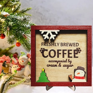 Christmas wooden coffee sign with snowman and tree motifs on a black stand