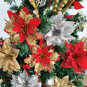 Sparkling artificial poinsettia flowers in red, gold, and silver on a Christmas tree