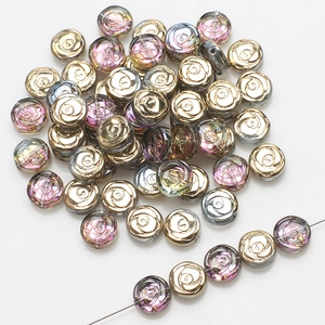 Macro detail of 10mm glass rose flower beads with gold and purple iridescent finish