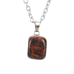 Macro detail of natural red and black jasper stone pendant on silver chain necklace