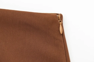 Détail du tissu sergé marron et de la fermeture éclair invisible sur l'ensemble jupe