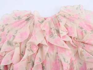Détail des couches de volants sur un chemisier en mousseline rose à imprimé floral chic