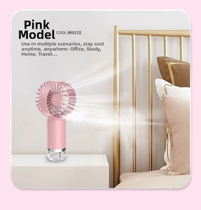 Pink handheld mist fan with mist humidifier function on a bedroom nightstand