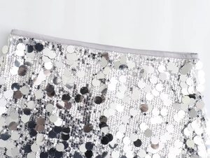 Detailed view of silver sequin mini skirt showing metallic texture and large round sequins