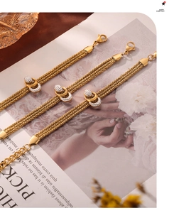 Detail of layered gold-plated mesh bracelets with rhinestone-encrusted interlocking rings