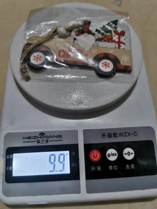 Digitale Waage zeigt das 9,9 g schwere Weihnachts-LKW-Ornament aus Holz für den Baum.