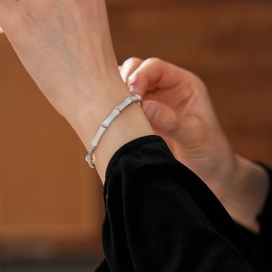 Detail of silver bamboo style bracelet with mother of pearl on female wrist